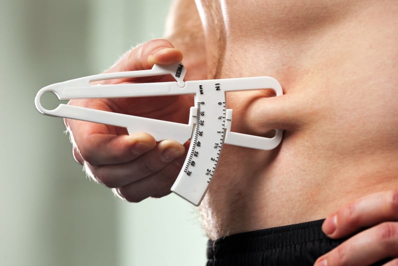 Person measuring body fat with a calipers