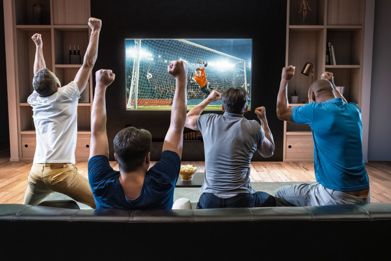Empat pria merayakan menonton sepak bola