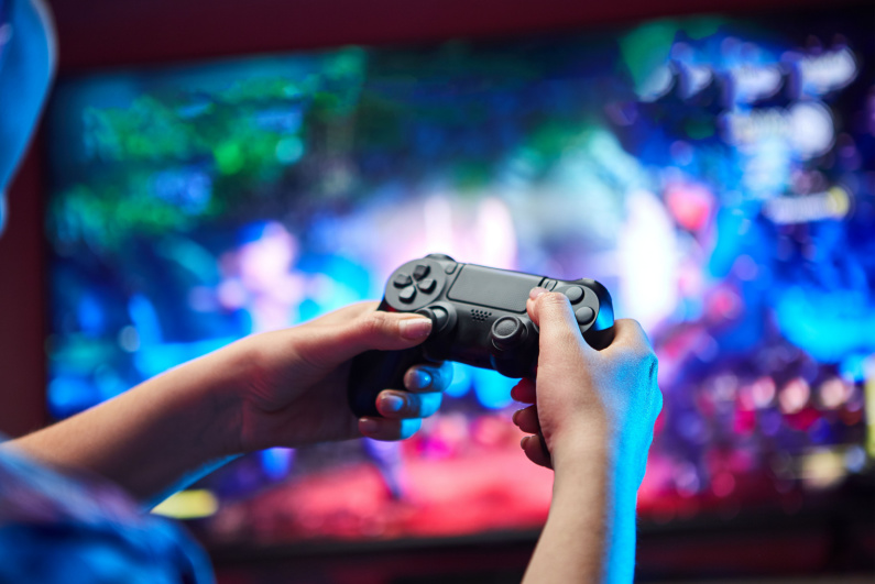 Gamer holding video game controller in front of TV