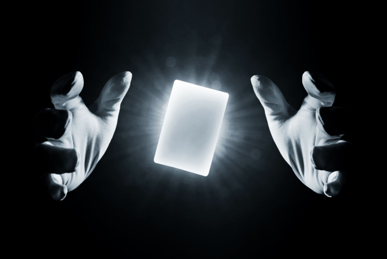 Glowing white card floating between two hands