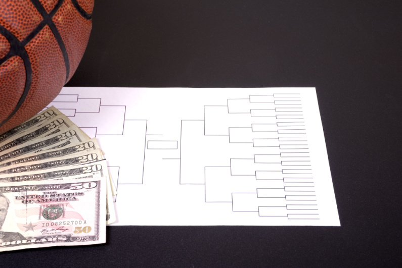 Tournament bracket sheet with a basketball and cash