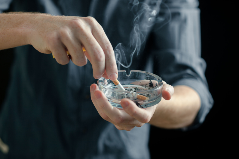 Man extinguishing a cigarette in an ashtray