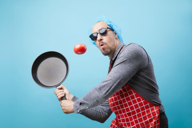 Cook hitting tomato with frying pan