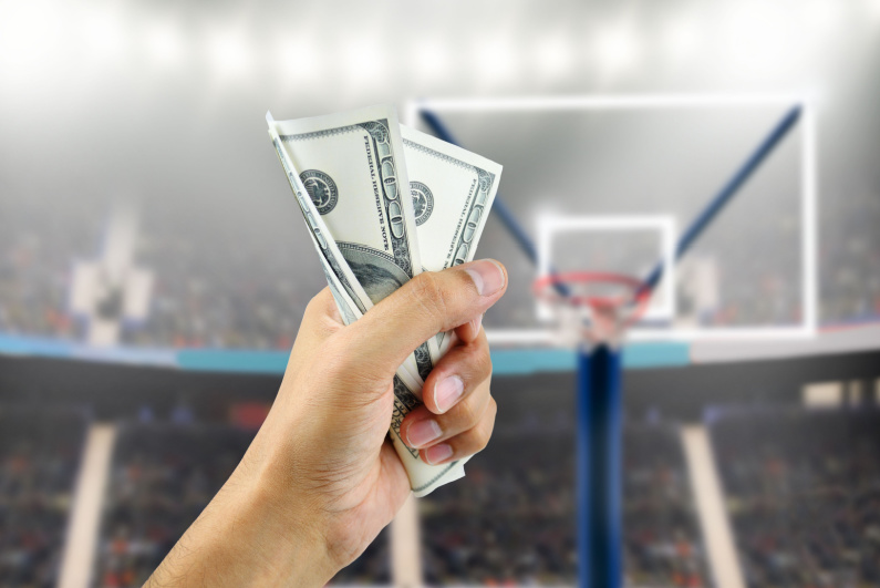 Person holding cash against basketball court background