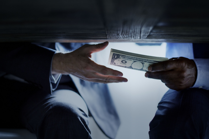 Businessman passing a bribe under a table