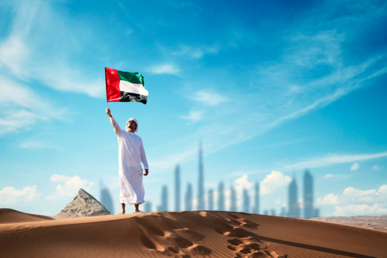 Seorang pria memegang bendera Uni Emirat Arab