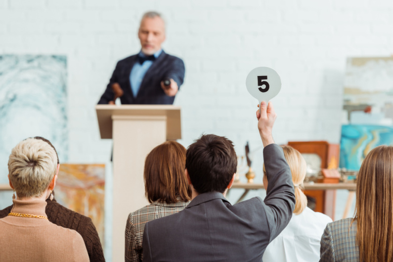 Man holding up paddle at auction