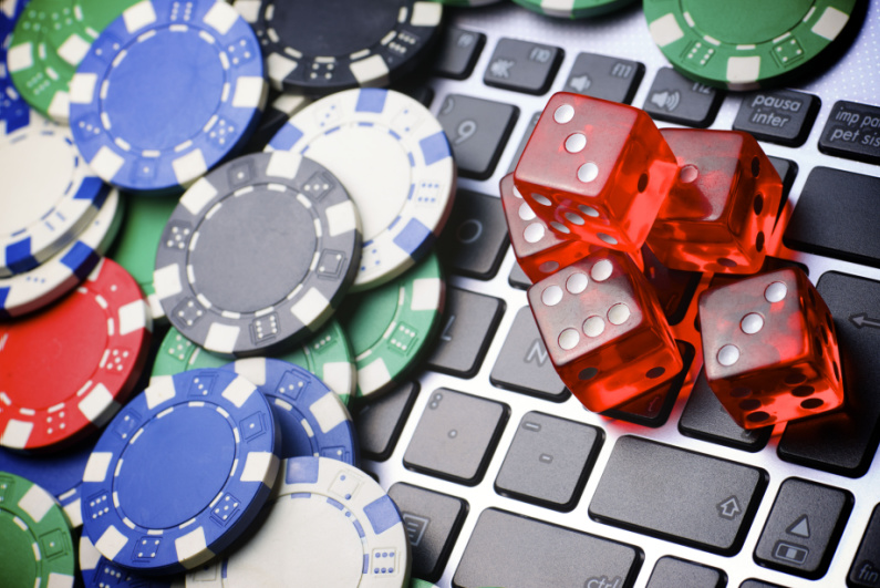 Poker chips and dice on a laptop keyboard