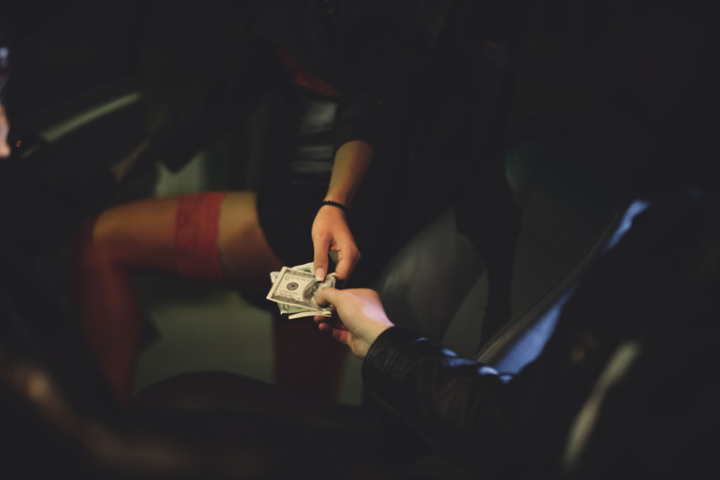 Person passing woman money in car