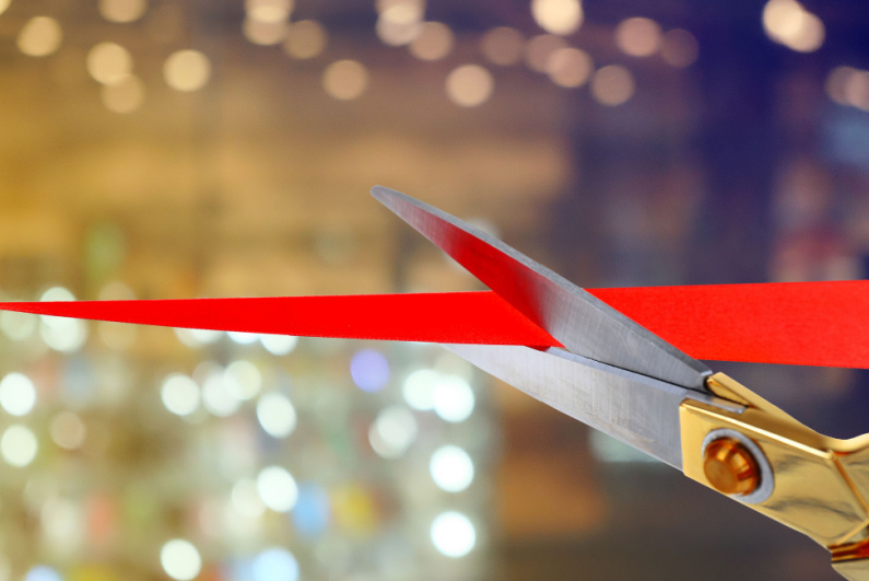 Scissors cutting red ribbon