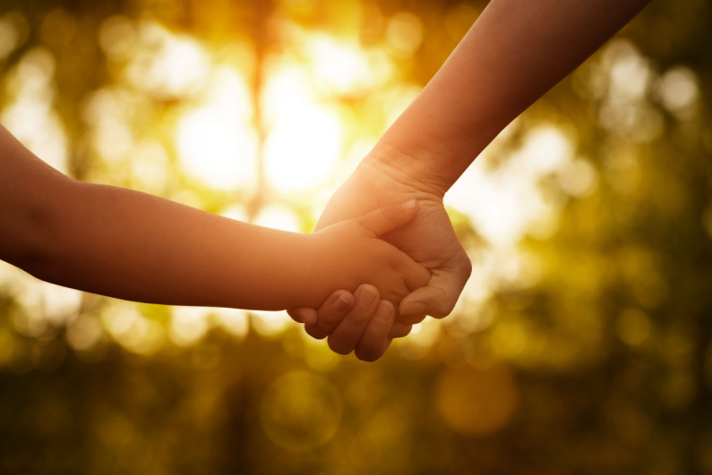 Woman holding child's hand