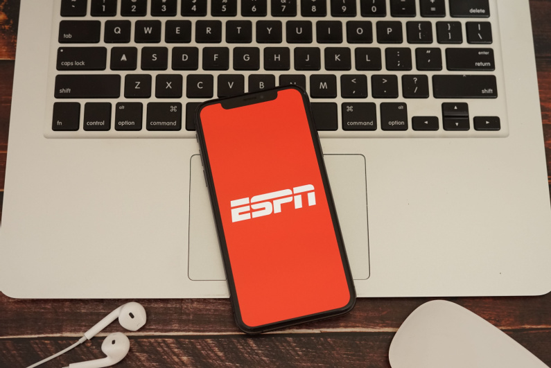 ESPN logo on a phone sitting on a laptop