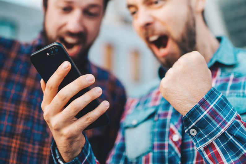 Two guys celebrate a successful sports bet