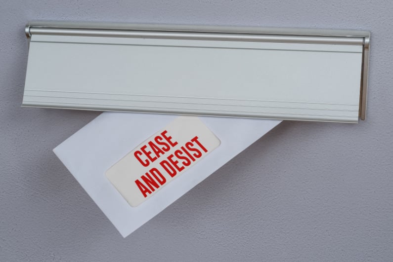 Cease and desist letter sticking through a mail slot