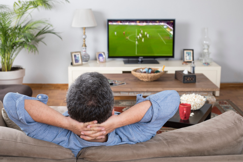 Man watching soccer game on TV