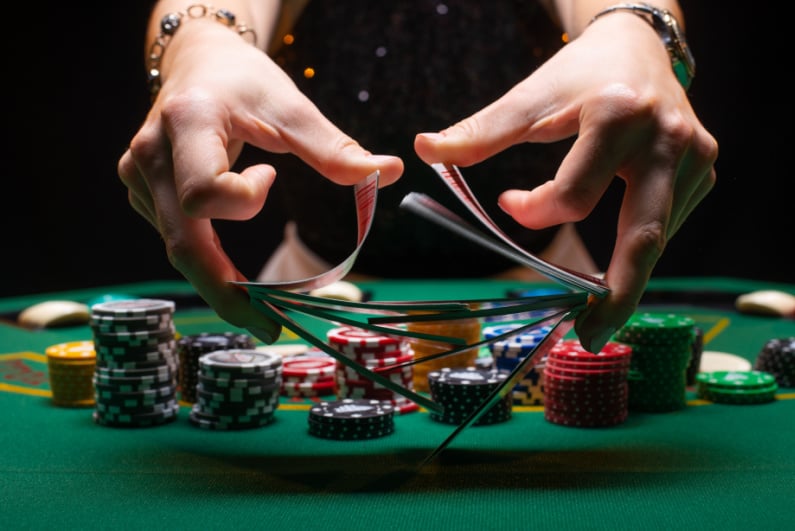 Poker chips and dealer shuffling cards