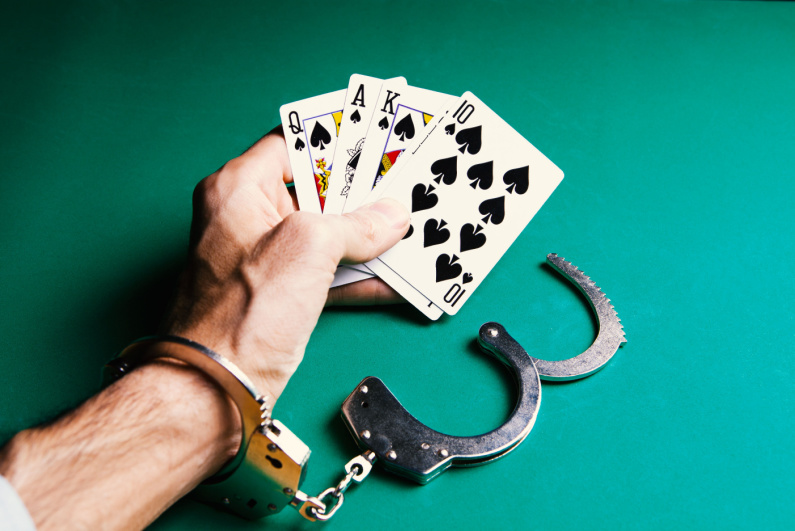 Cards in hand with handcuffs