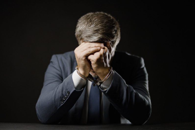 Man in handcuffs and business suit