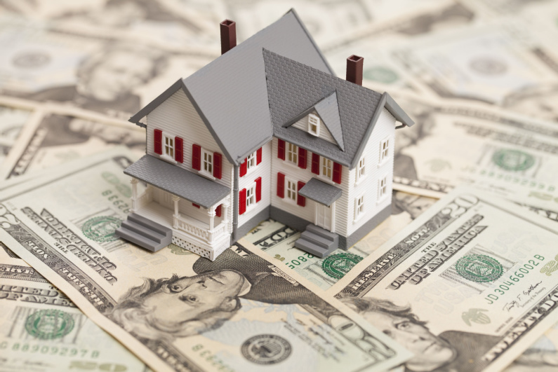 Model of a house on top of cash