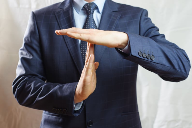 Businessman making time out gesture