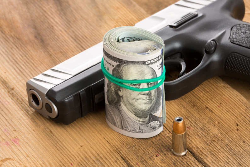 Handgun with a roll of cash