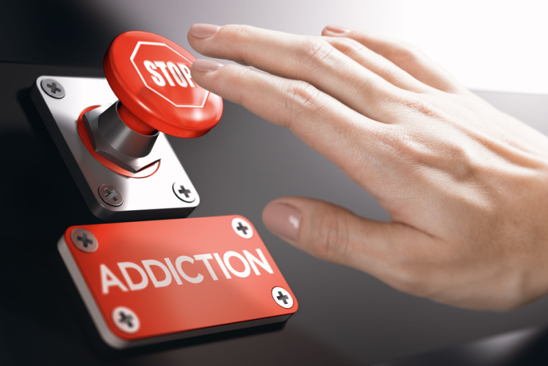 Person pressing a _STOP_ button next to an _ADDICTION_ poster