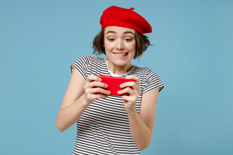 Woman in red beret playing game on phone