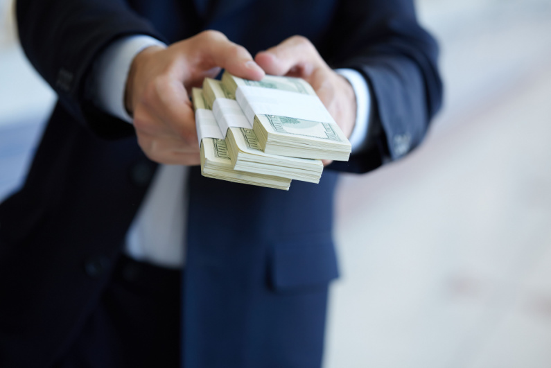 Businessman handing over stacks of cash