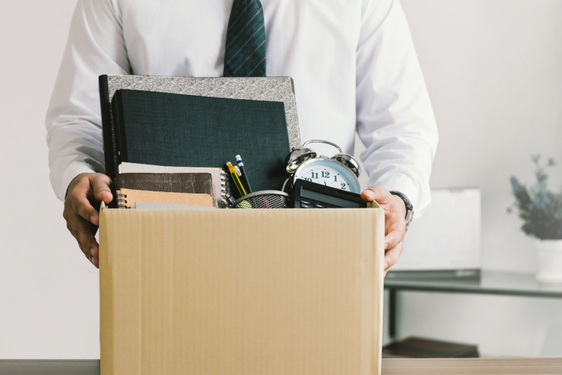 Man with desk belongings in box