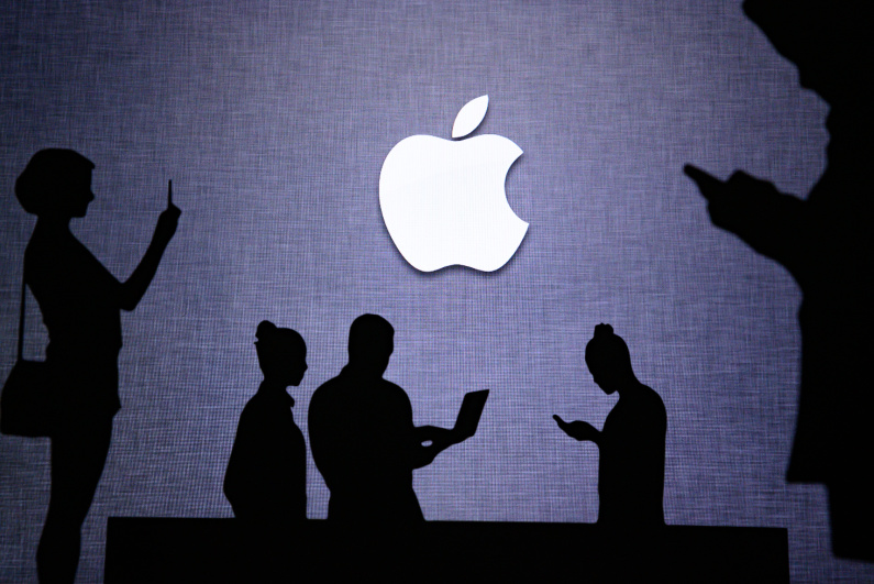 Apple logo surrounded by silhouettes of people using devices