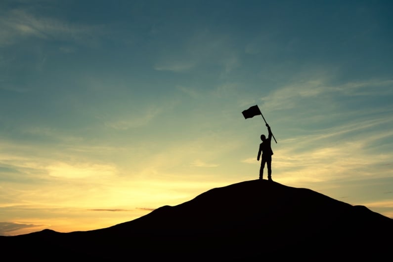 Person holding flag on hill