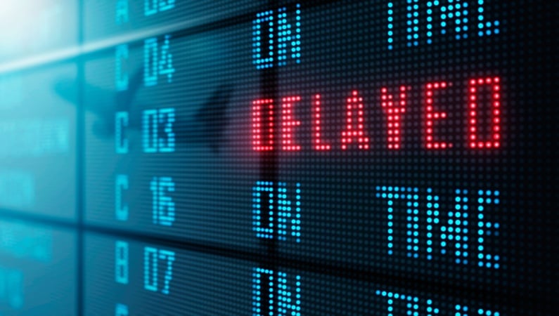 Airport flight status board highlighting DELAYED