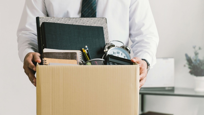 Businessman holding box of office items