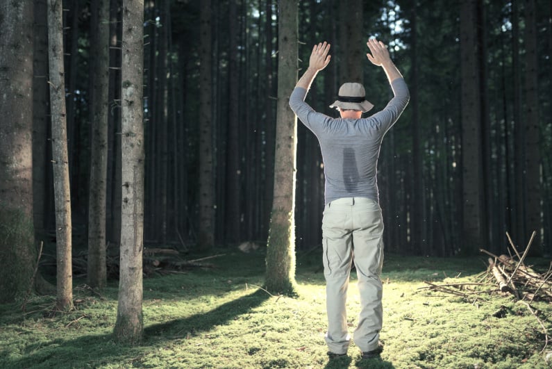 Man being arrested in the woods