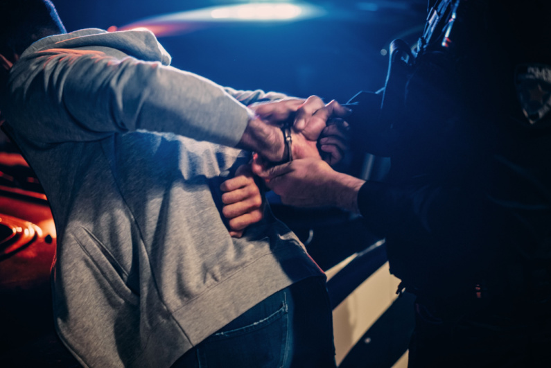 Policeman handcuffs suspect