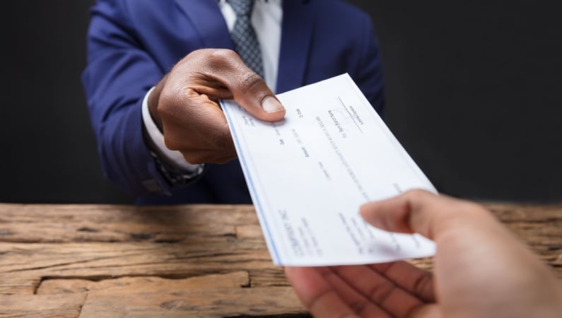 Businessman handing someone a check