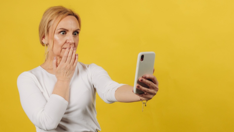 Mature woman shocked at what she sees on her phone