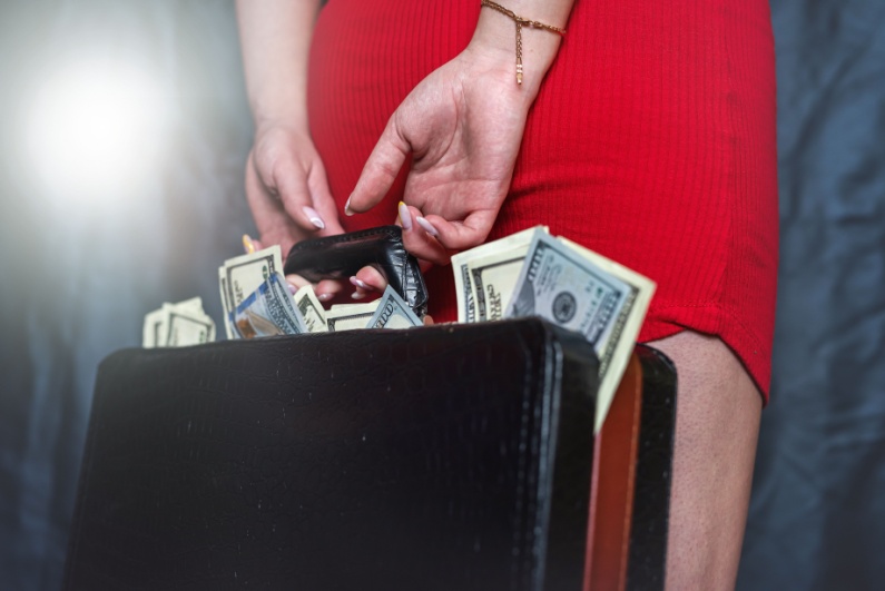 Woman holding briefcase of cash behind her back