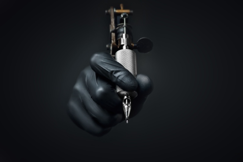 Hand holding a tattoo gun