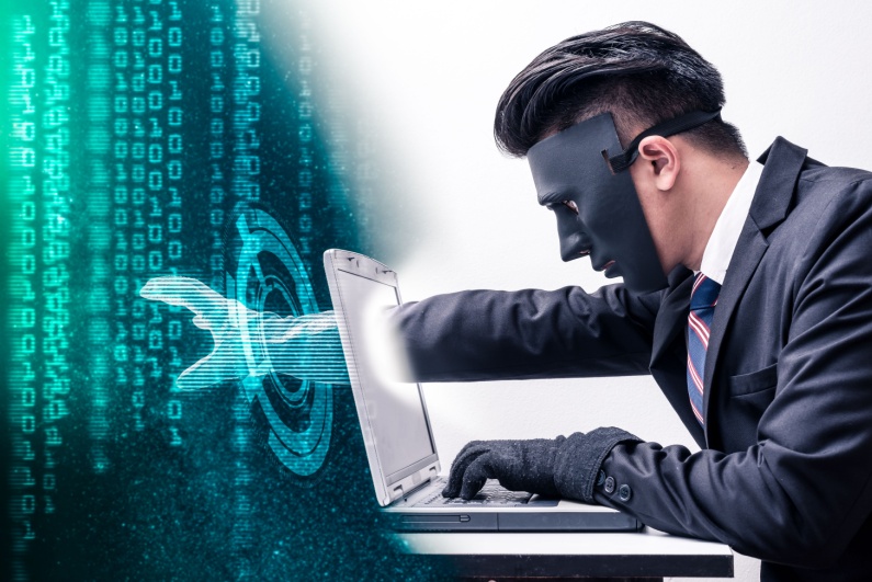 Masked man stealing through a computer