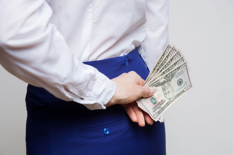 Woman holding cash behind her back