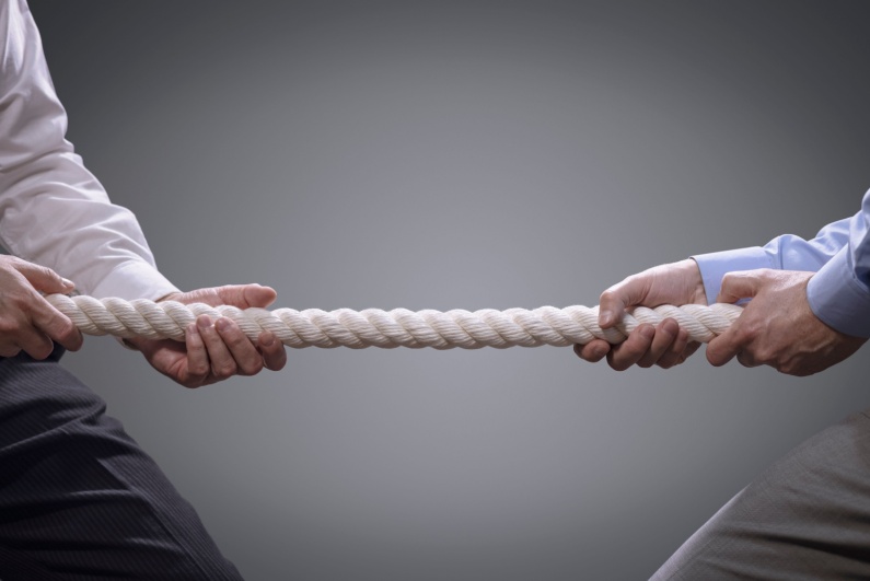 Businessmen playing tug of war