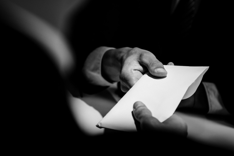 Black and white photo secret cash envelope handoff