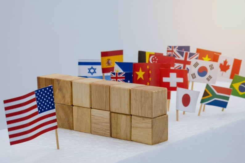 American flag separated from other flags by wall of blocks