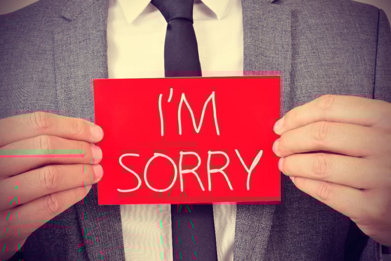Man holding I'M SORRY card