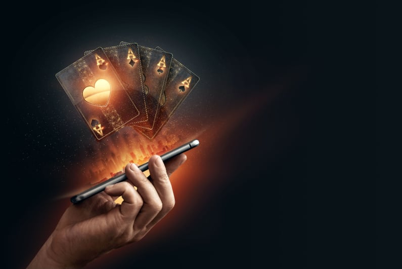 Black and gold playing cards hovering above phone