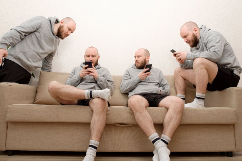 Cloned men looking at their phones