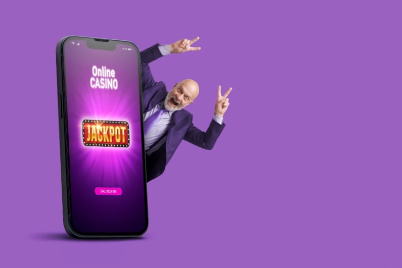Man celebrating online casino jackpot behind human-sized phone