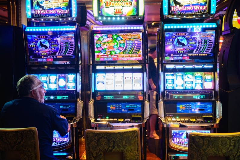 Man sitting at a bank of slot machines