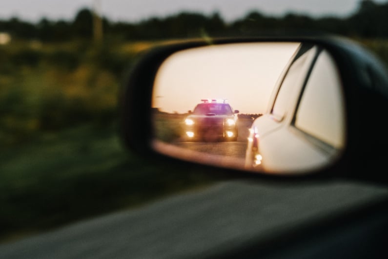 Police car in side mirror